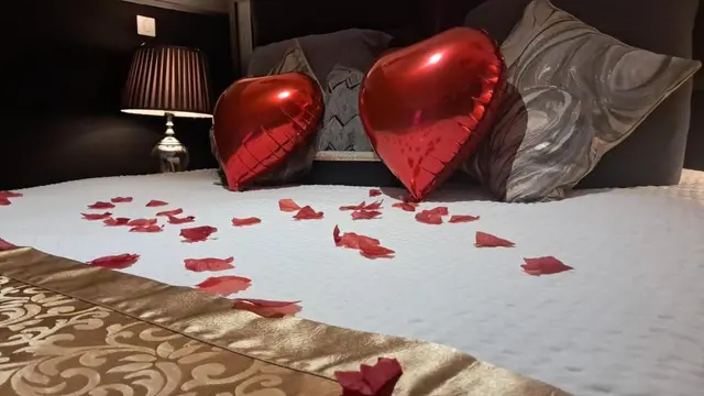 Ballons cœur et pétales sur le lit