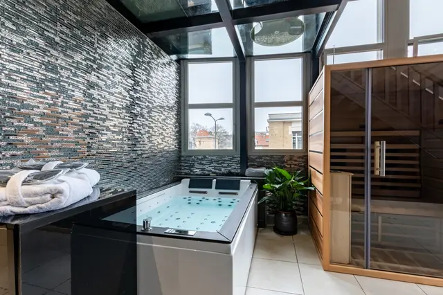 Le jacuzzi et le sauna contre le mur de pierre